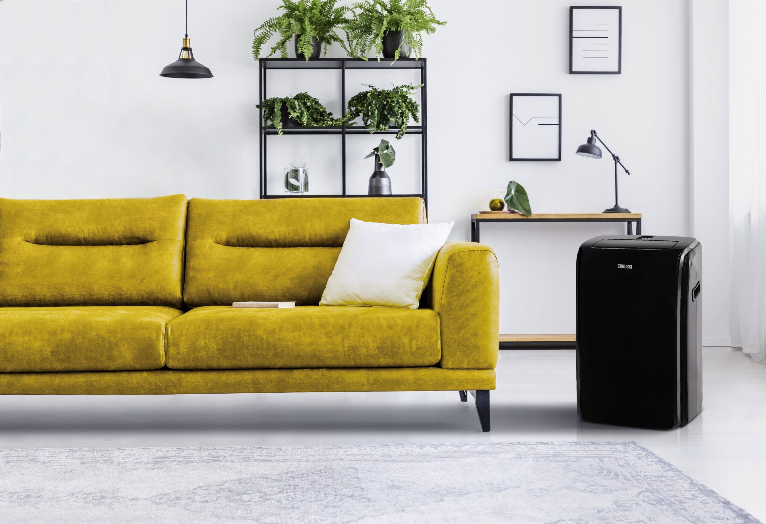 White pillow and book on brown leather couch in spacious interior full of plants